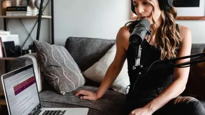 A podcaster recording her audio on a laptop