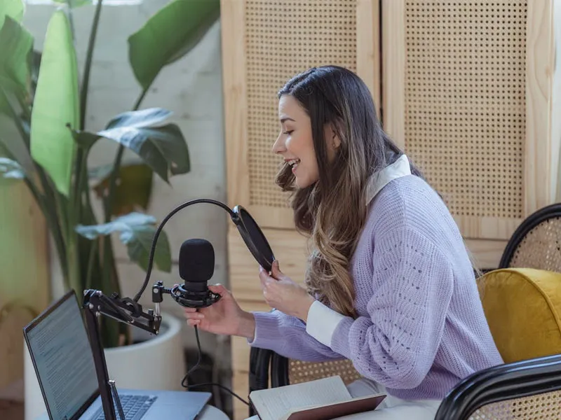 A happy podcaster recording in a comfortable space