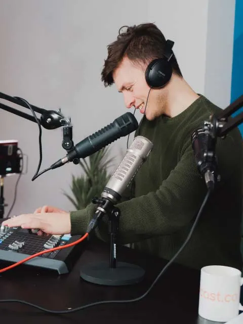 Our podcast producer recording at a desk 