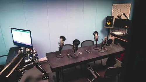A soundproofed room with a recording setup including computer, microphones and speakers